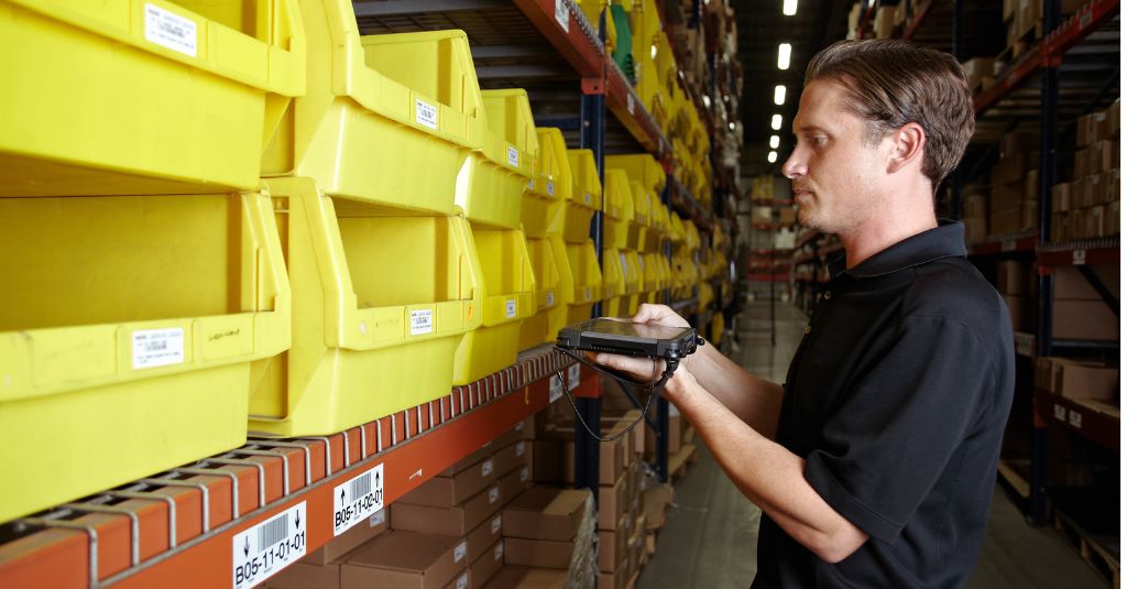 warehouse worker scanning stocks using barcode reader in rugged tablet
